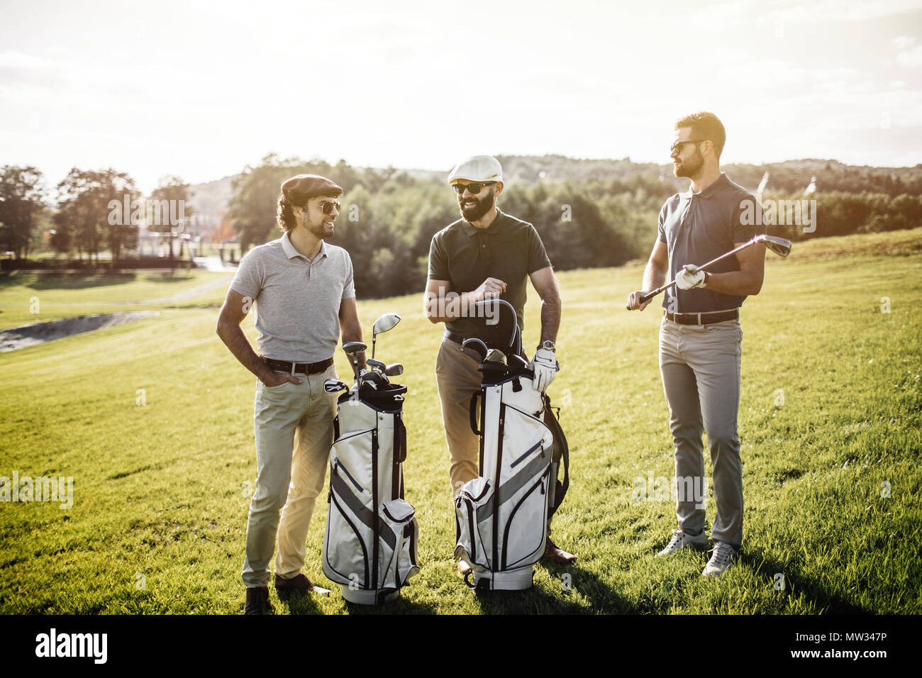 Group of friends walking on the golf course Stock Photo