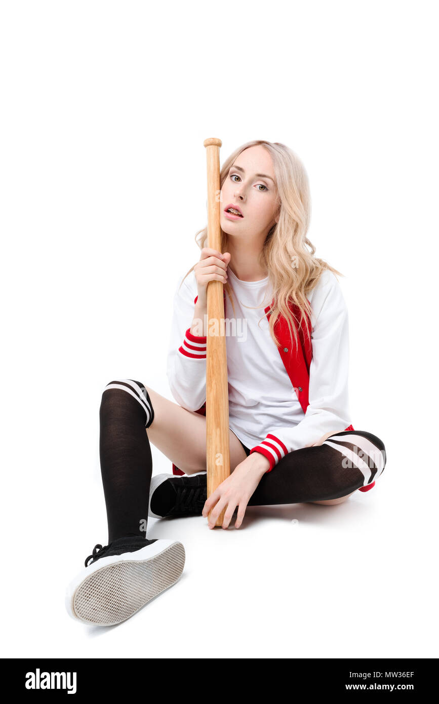 Full length shot of a young woman sitting on a floor and holding a