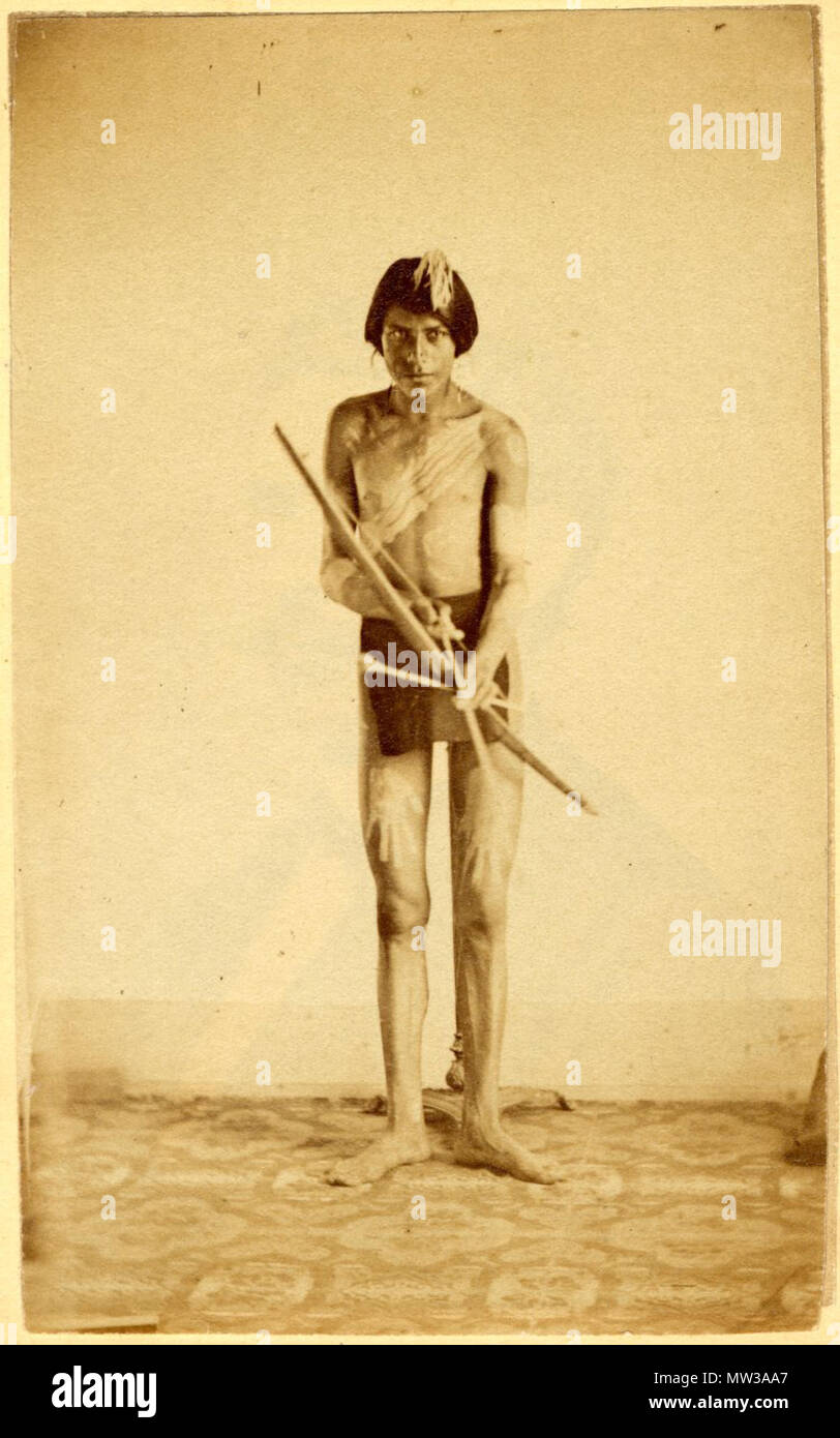 . Young Pawnee man holding bow and arrow . Photograph, studio portrait of a young Pawnee man holding a bow and two arrows, his body is decorated with white paint, a wide diagonal line crosses his chest, two bands circle his arms and two imprints of hand palms on his thighs; wearing waist cloth. 19th century  658 Young Pawnee man holding bow and arrow Stock Photo
