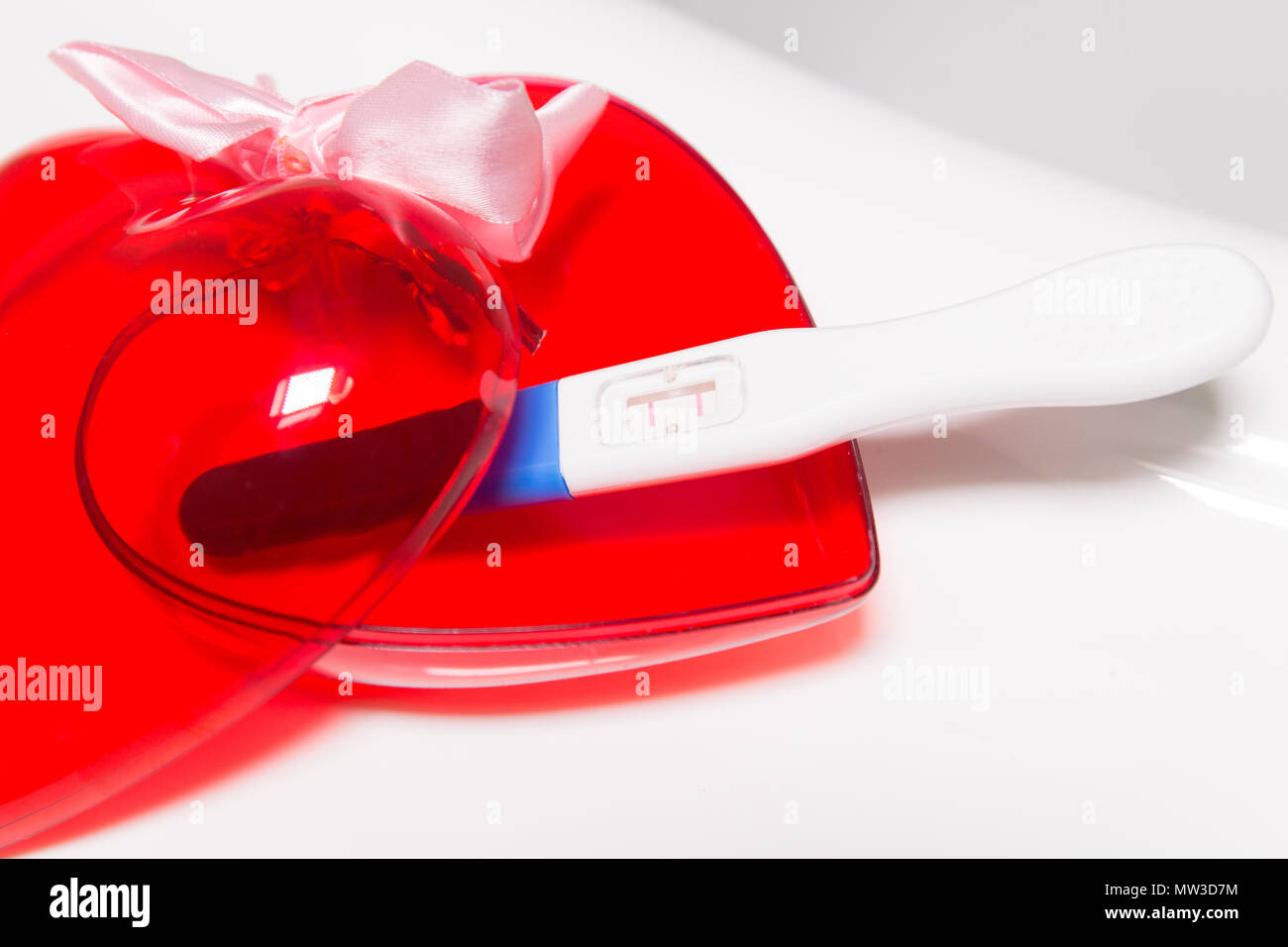 Positive pregnancy test and heart on bathtub Stock Photo Alamy