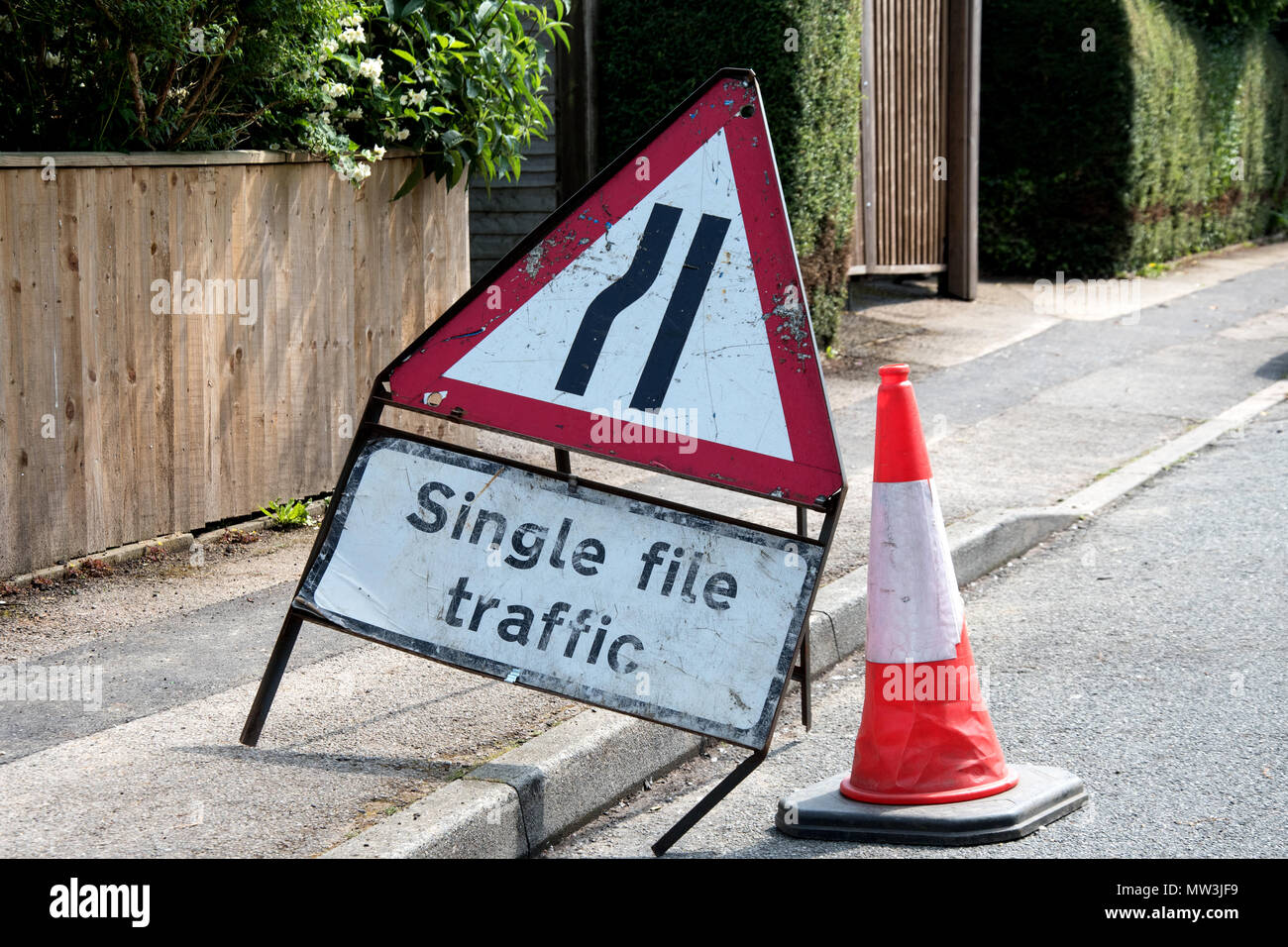 UK road sign. Road narrows from left single file traffic Stock Photo