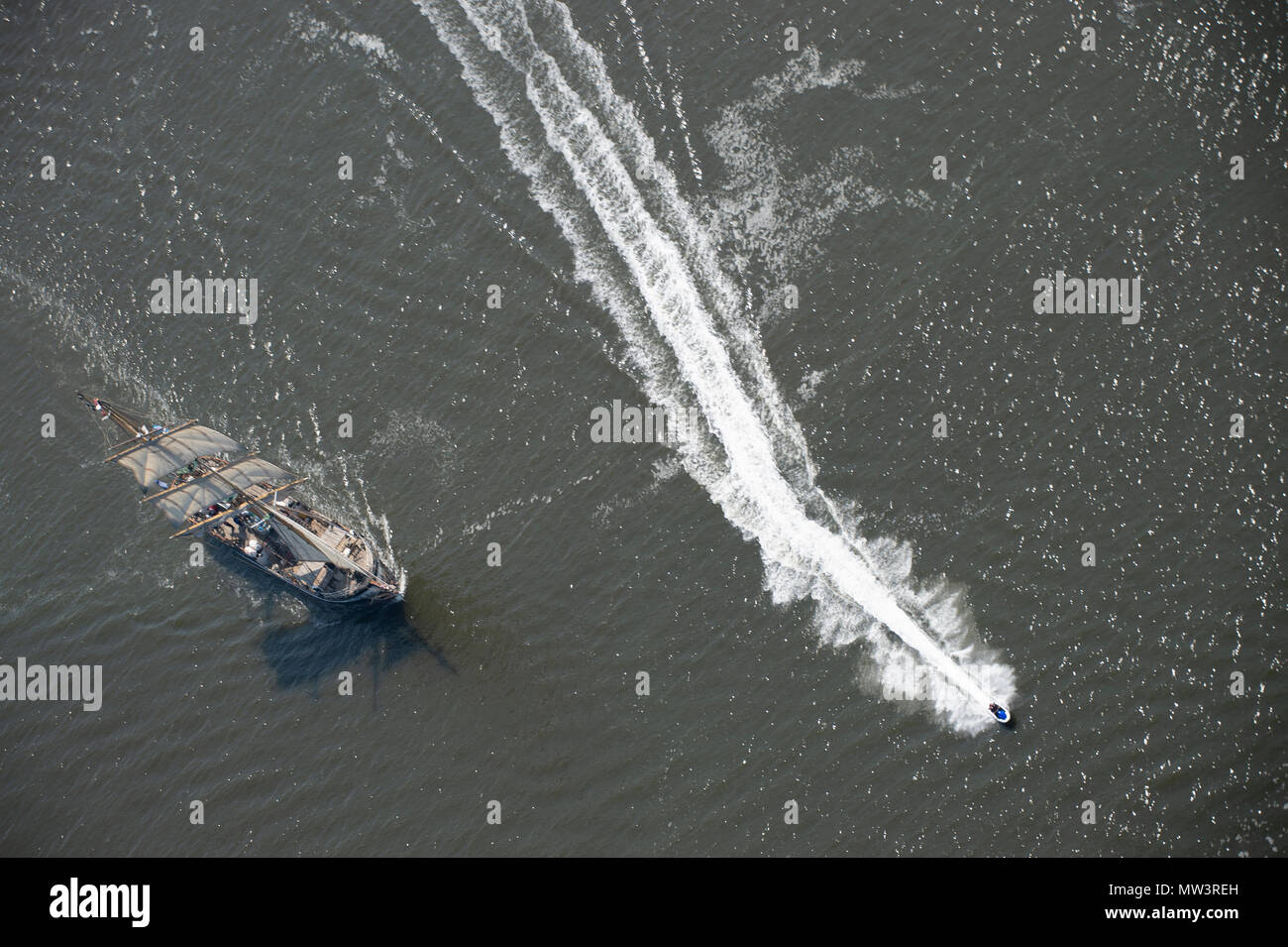 Aerial photo of tall ships leaving Liverpool on River Mersey with speedboat passing Stock Photo