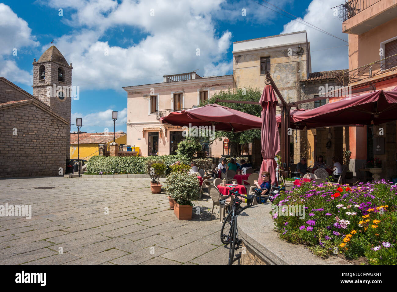 Cyclist drinking coffee outside a cafe in Arzachena square, Sardinia Stock Photo