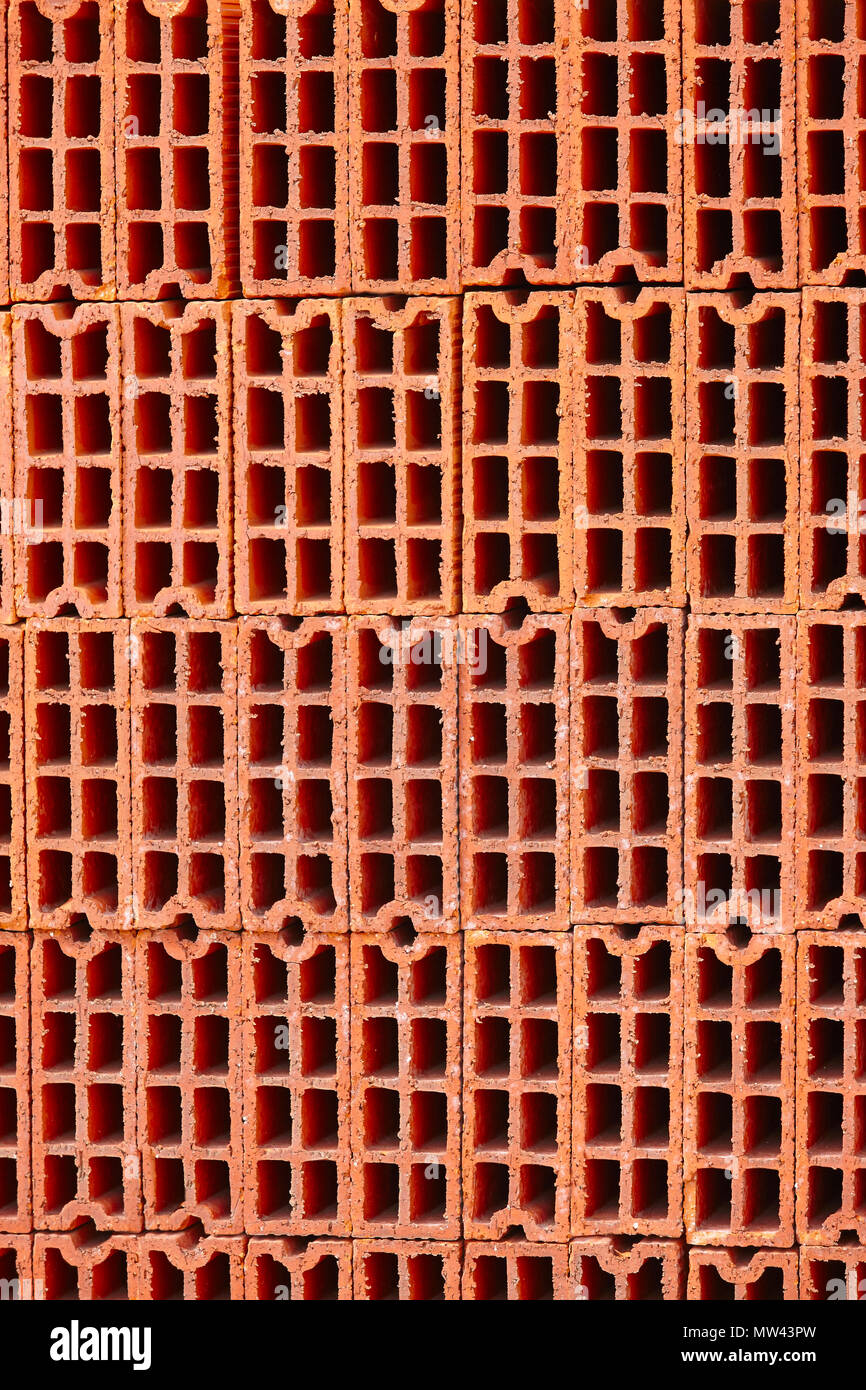 Stacked orange bricks. Construction industry. Industrial objects. Architecture. Vertical Stock Photo