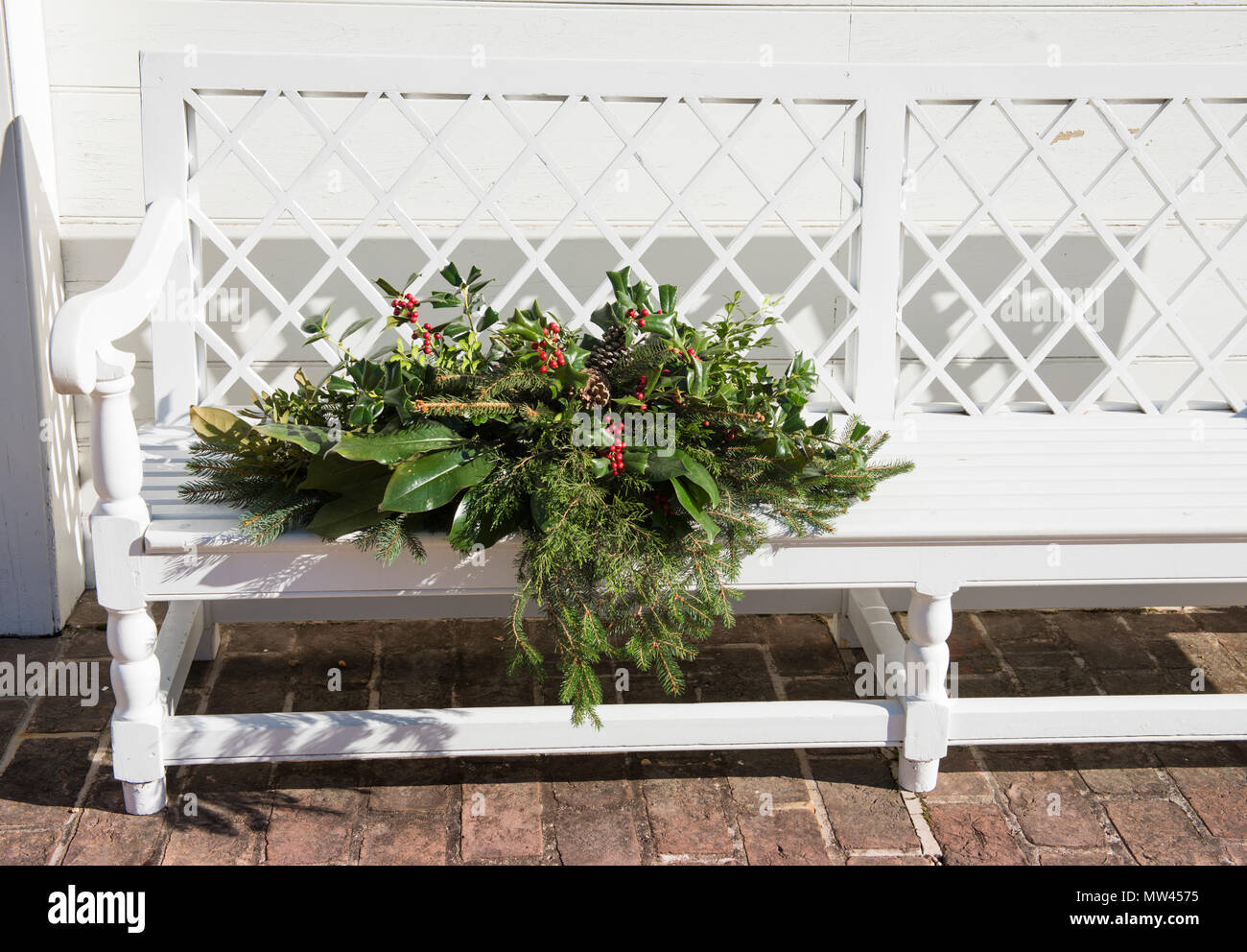 Holly wreath & display on a white bench on the property of the historic Rockefeller home in Colonial Williamsburg, VA. Basset Hall at Christmas. Stock Photo