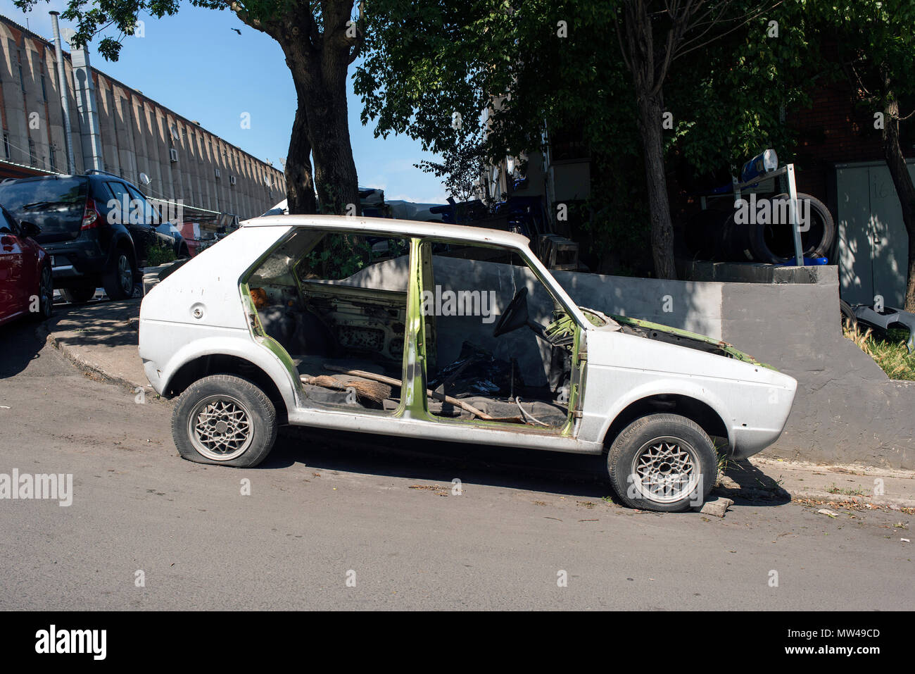 A Wrecked Car Without Doors In The Street Stock Photo