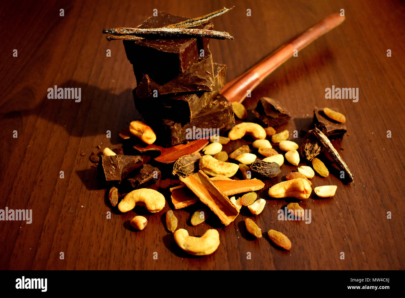 Still life with dark chocolate, sugar coated vanilla pods, nuts and spices. Stock Photo
