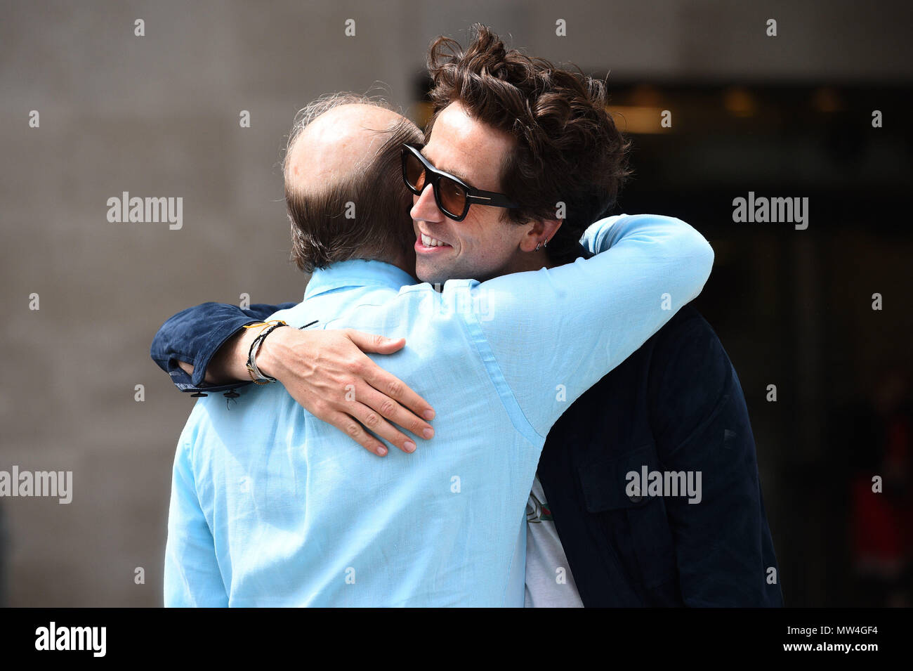 Nick Grimshaw hugs a man as he leaves Broadcasting House in central London after announcing that he will step down from hosting the BBC Radio 1 Breakfast Show after six years. Stock Photo