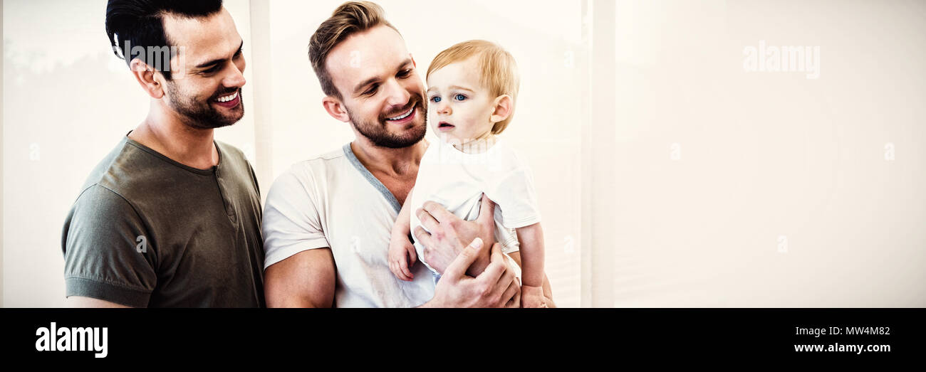 Gay couple with child at home Stock Photo