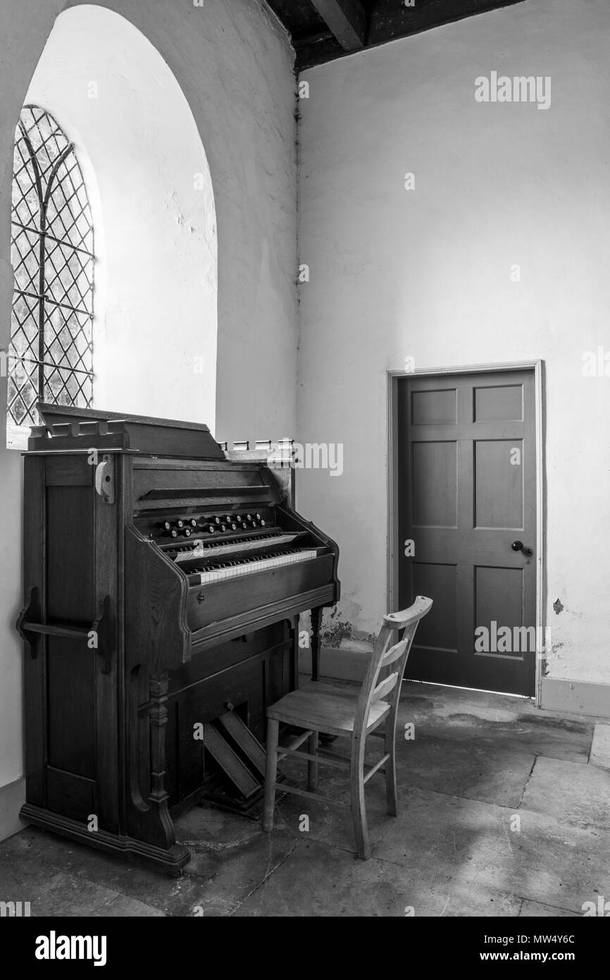 Interior b & w of quaint historic St Martin's Church (small traditional wooden organ in corner) -  Allerton Mauleverer, North Yorkshire, England, UK. Stock Photo