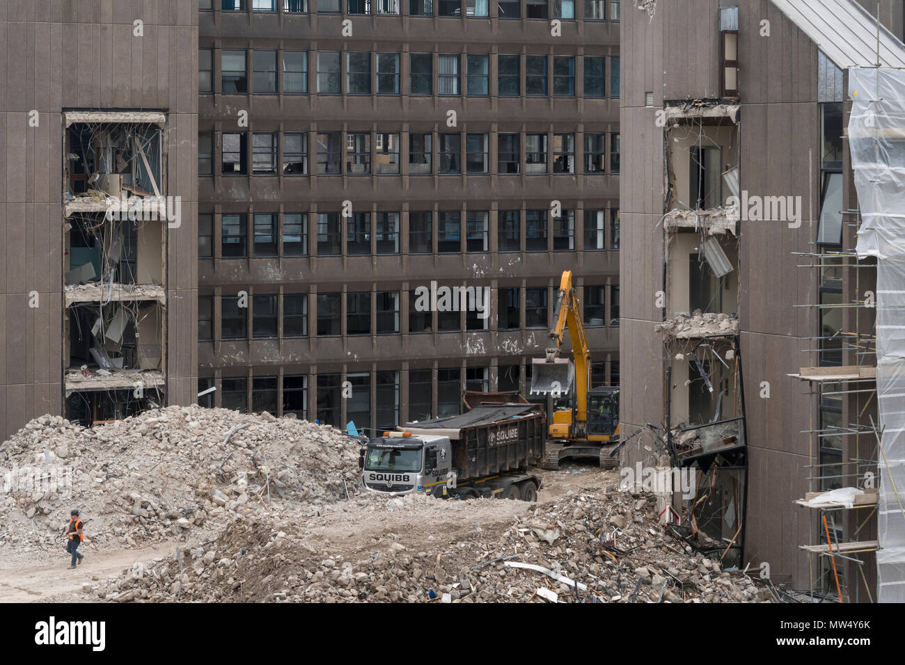 High view of demolition site debris - heavy machinery (excavator & dump truck) working & demolishing office building - Hudson House  York, England, UK. Stock Photo
