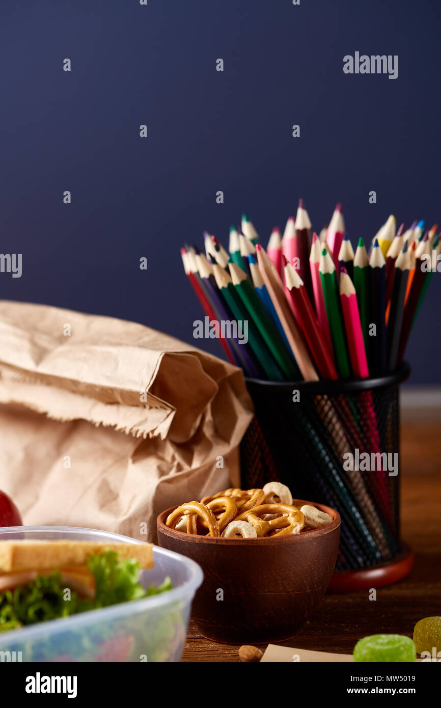 Back to School concept, school supplies, assortment of biscuits and transparent lunchbox full of sandwich, fruits and vegetables togather with assortm Stock Photo