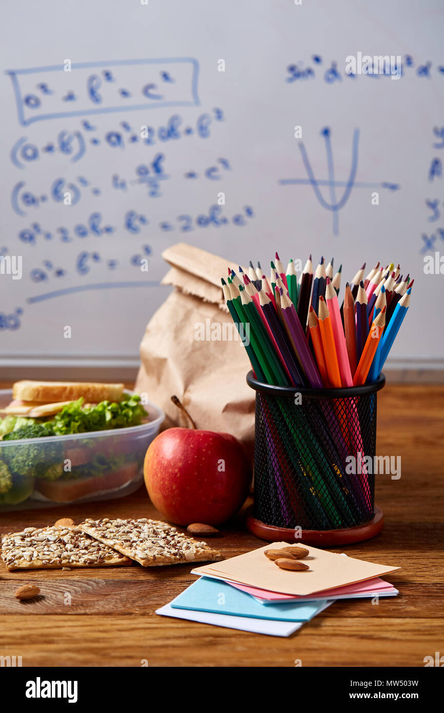 Back to School concept, school supplies, assortment of biscuits and transparent lunchbox full of sandwich, fruits and vegetables togather with assortm Stock Photo