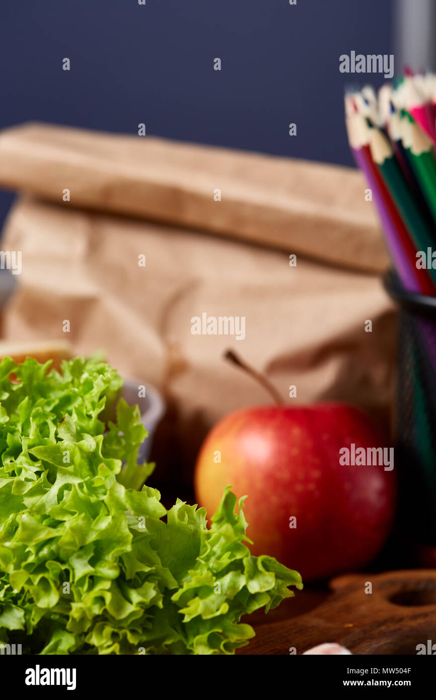 Back to School concept, school supplies, assortment of biscuits and transparent lunchbox full of sandwich, fruits and vegetables togather with assortm Stock Photo