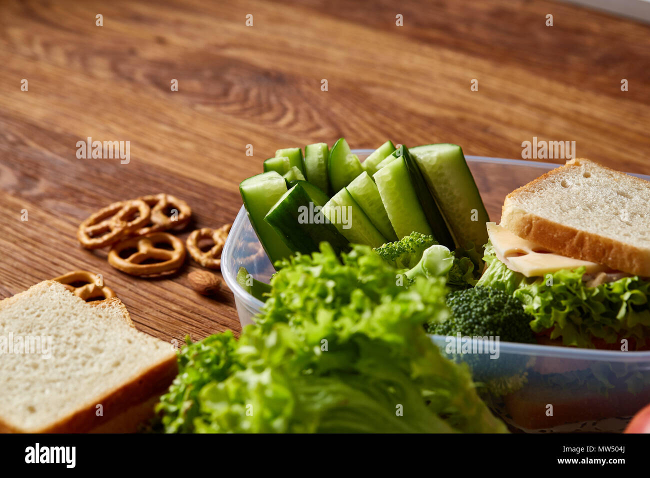 Back to School concept, school supplies, assortment of biscuits and transparent lunchbox full of sandwich, fruits and vegetables togather with assortm Stock Photo