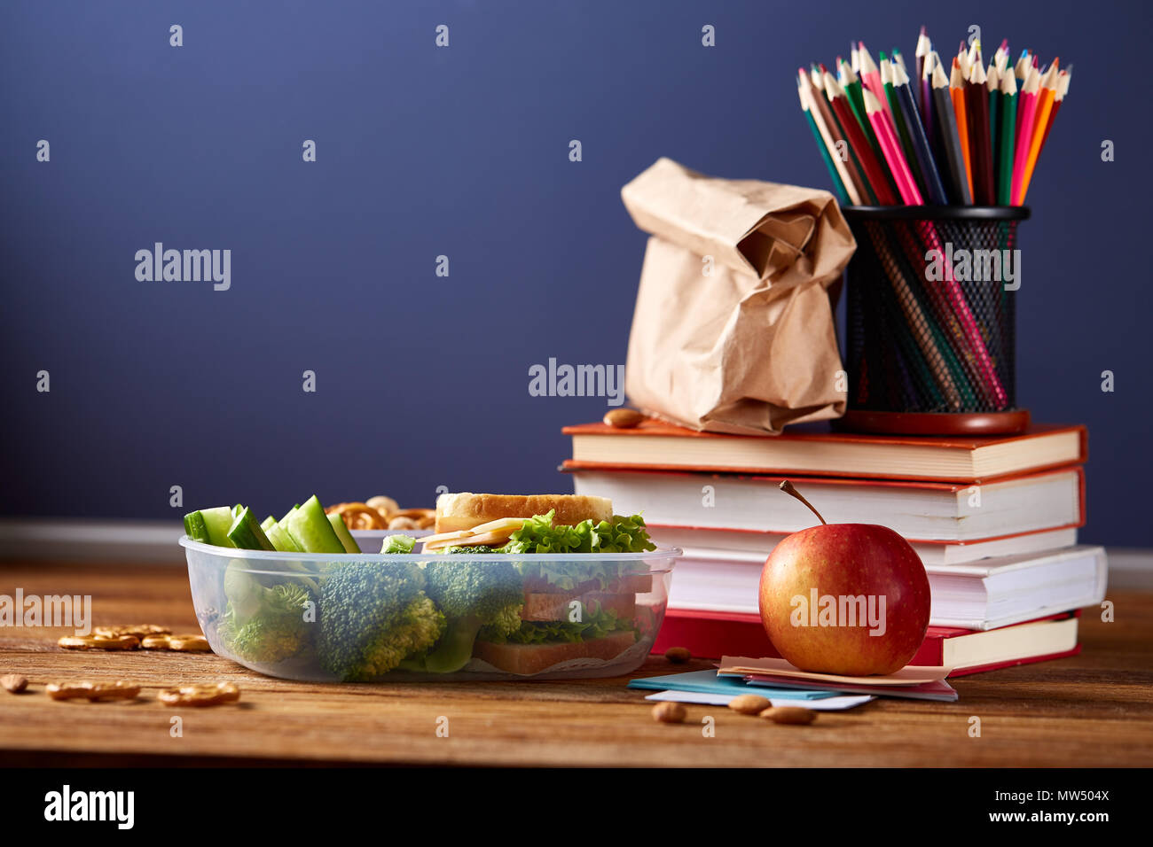 Back to School concept, school supplies, assortment of biscuits and transparent lunchbox full of sandwich, fruits and vegetables togather with assortm Stock Photo