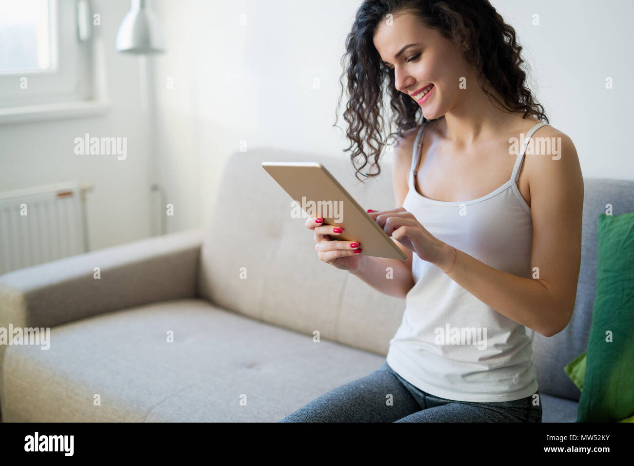 Beautiful woman at home working with tablet Stock Photo - Alamy