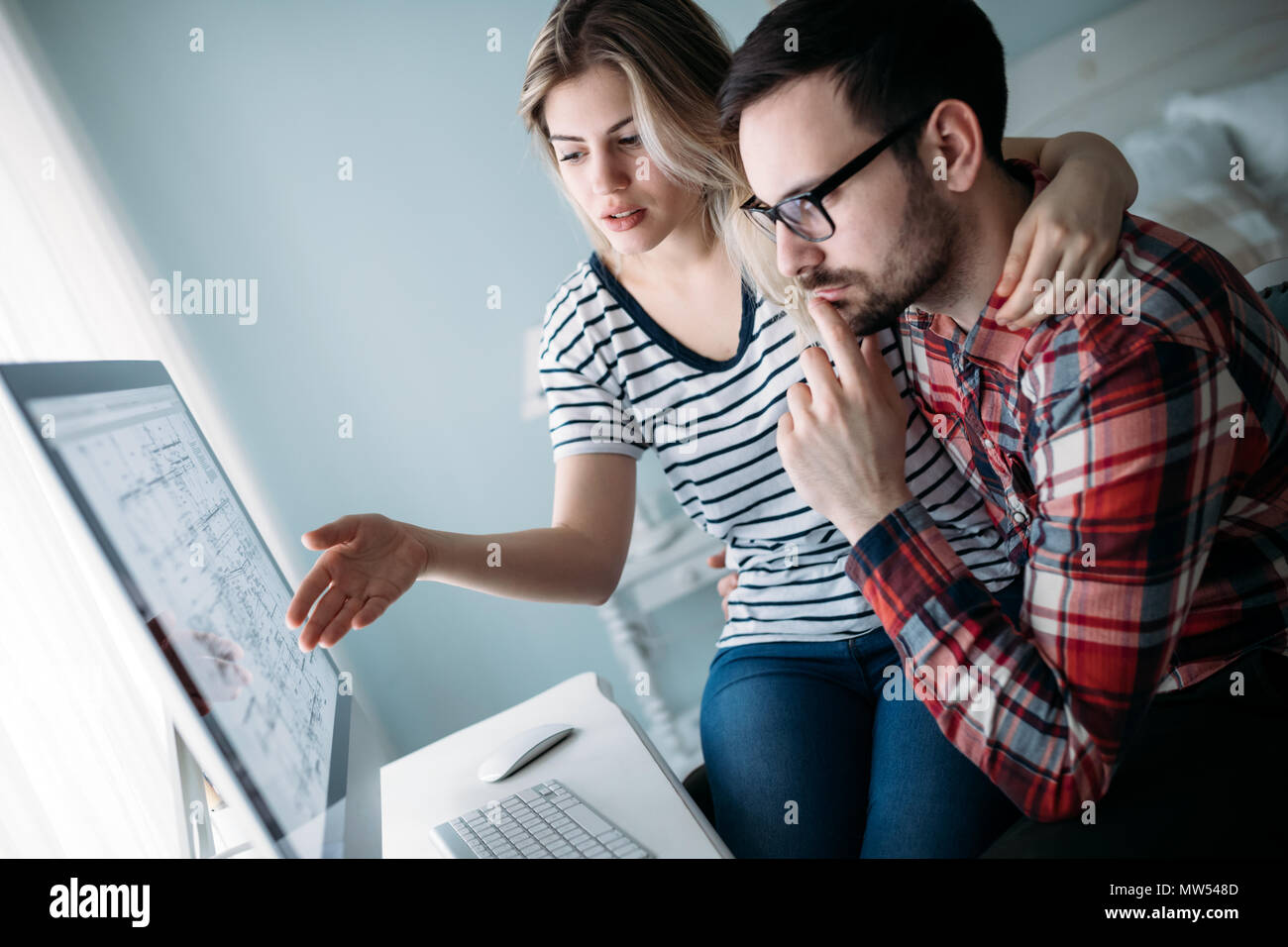 Young attractive designers working on project together Stock Photo