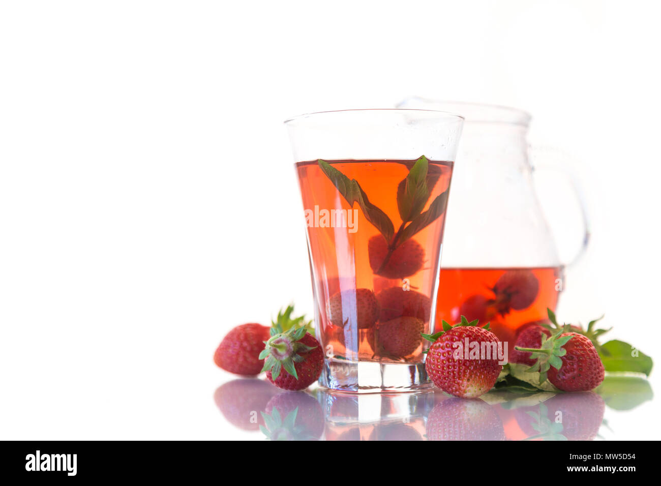 Sweet compote of ripe red strawberries in a glass decanter on a white background Stock Photo
