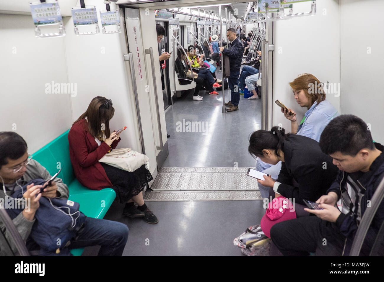 subway,metro,train,addiction,addict,mobile,phone,devices,Beijing,Peking,capital,city,Peoples Republic of China,China,Chinese,Asia,Asian, Stock Photo