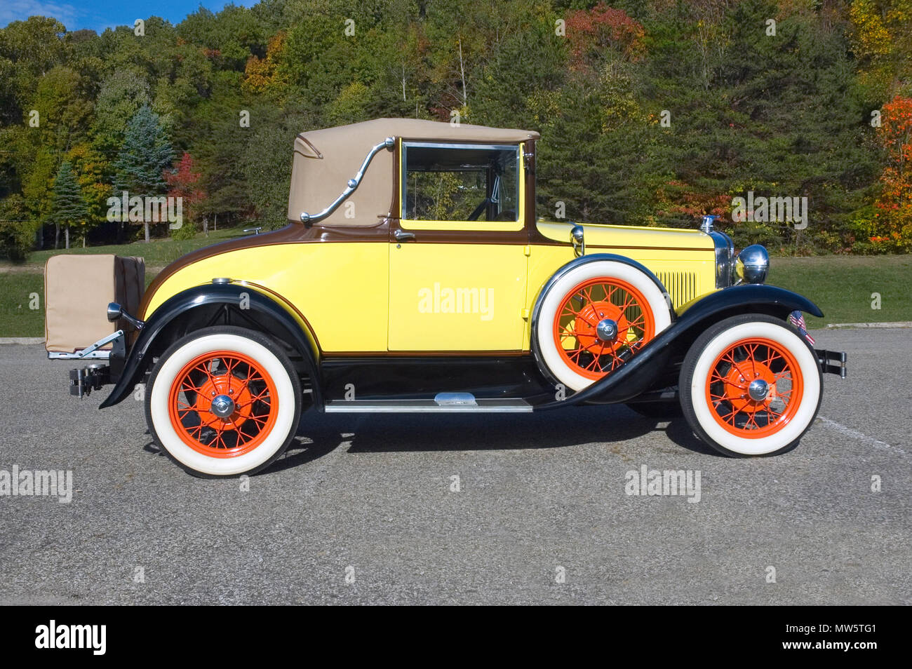 Antique 1931 Ford Model 'A' with an unusual but authentic paint scheme.  The colors of the car match the fall pallet of the trees in the background. Stock Photo