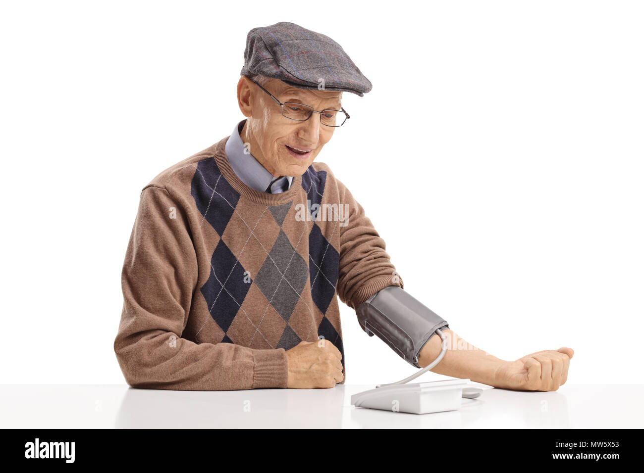 Mature man sitting at a table and measuring his blood pressure isolated on white background Stock Photo