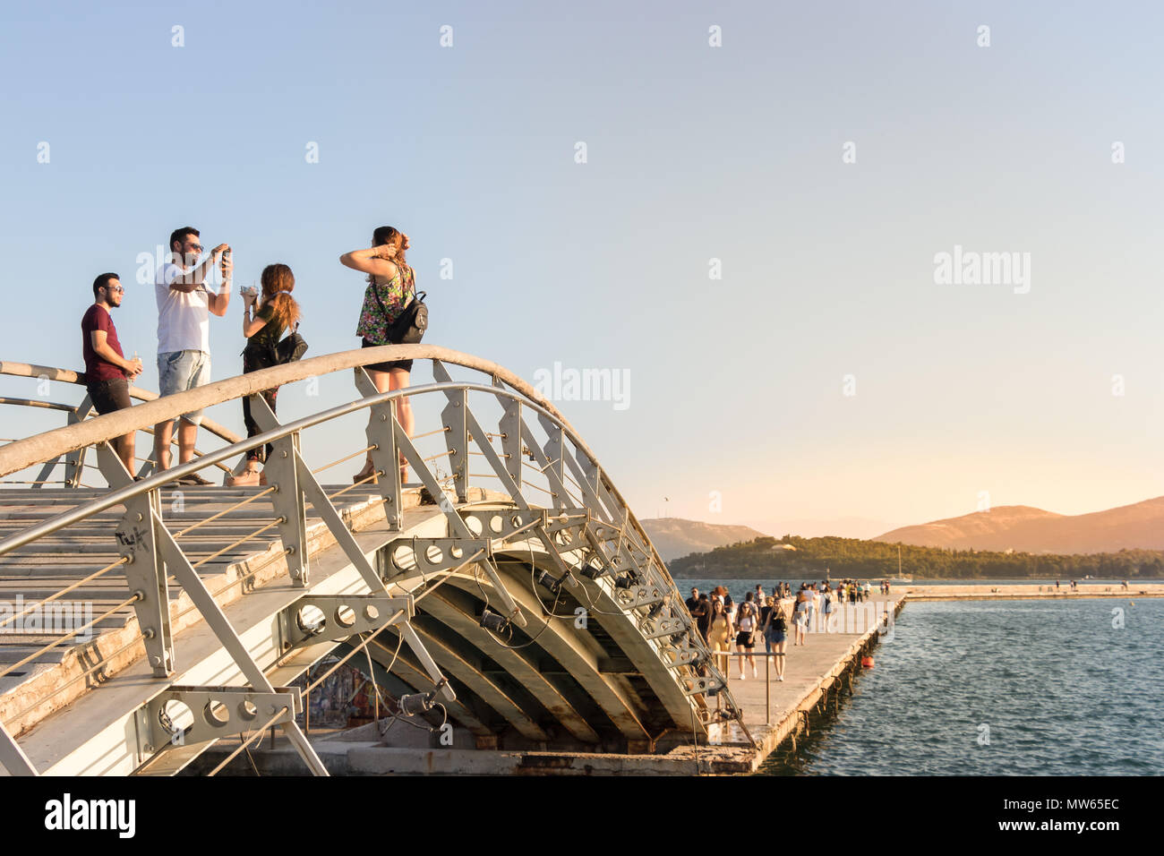 Volos, Thessaly, Greece - May 27th, 2018: People walking and taking photos on a little bridge at the Port of Volos, Pagasetic Gulf. Stock Photo