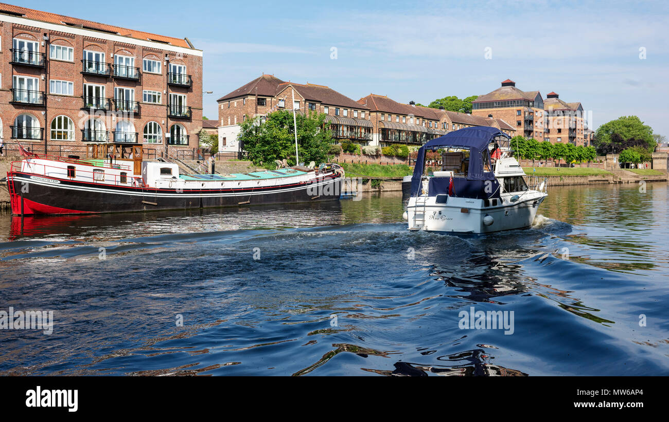 A modern family cruiser sailing past an older Dutch Barge, River Ouse, York, UK Stock Photo
