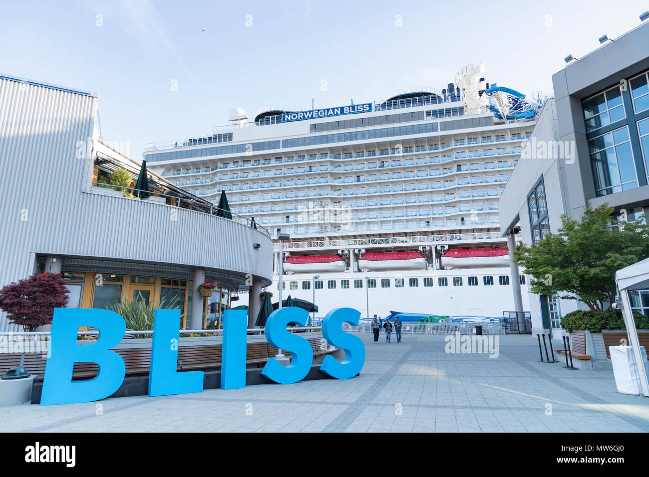 Norwegian Cruise Line ship Bliss docked at sunset in Seattle Washington christening ceremony with large sign of ships name. Stock Photo