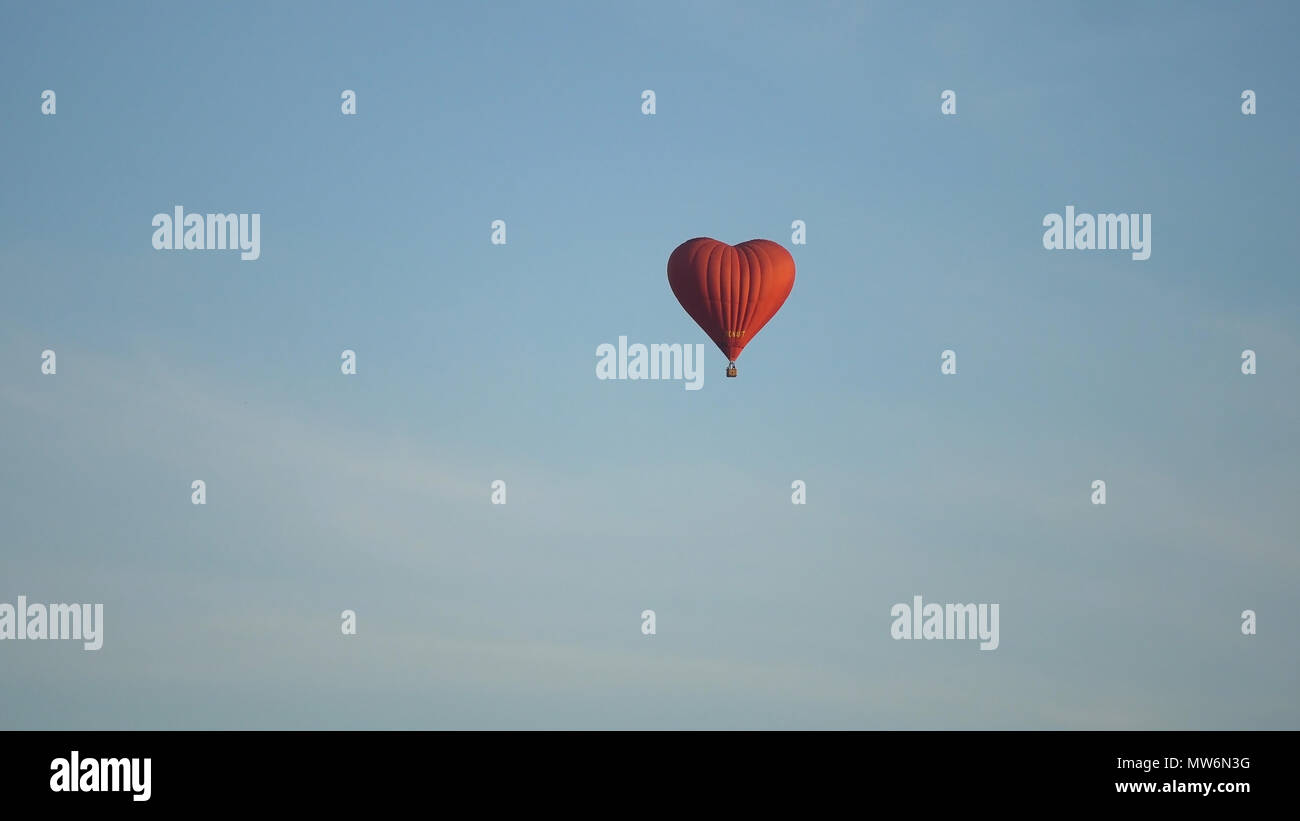 Hot air balloon shape of a heart in the blue sky. Aerostat, Airship ...