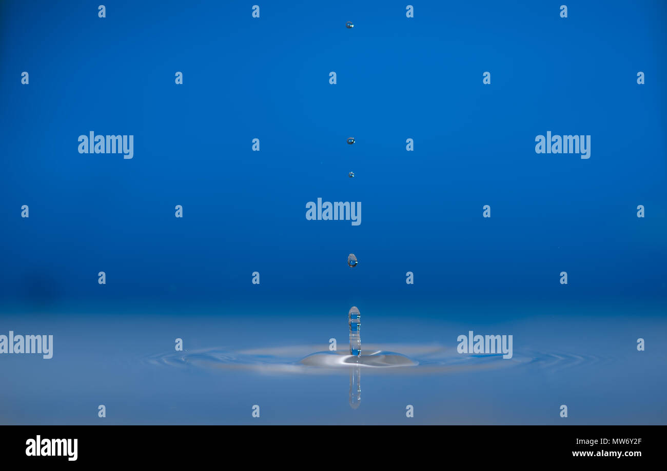 Water drop falling into water making a perfect droplet splash Stock