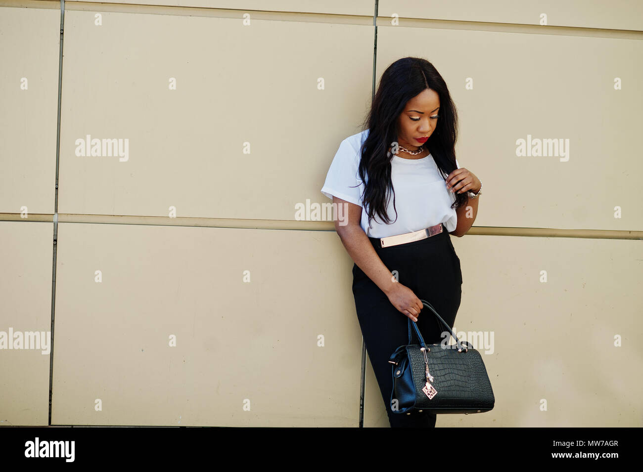 Stylish african american business woman with handbag on streets of city ...