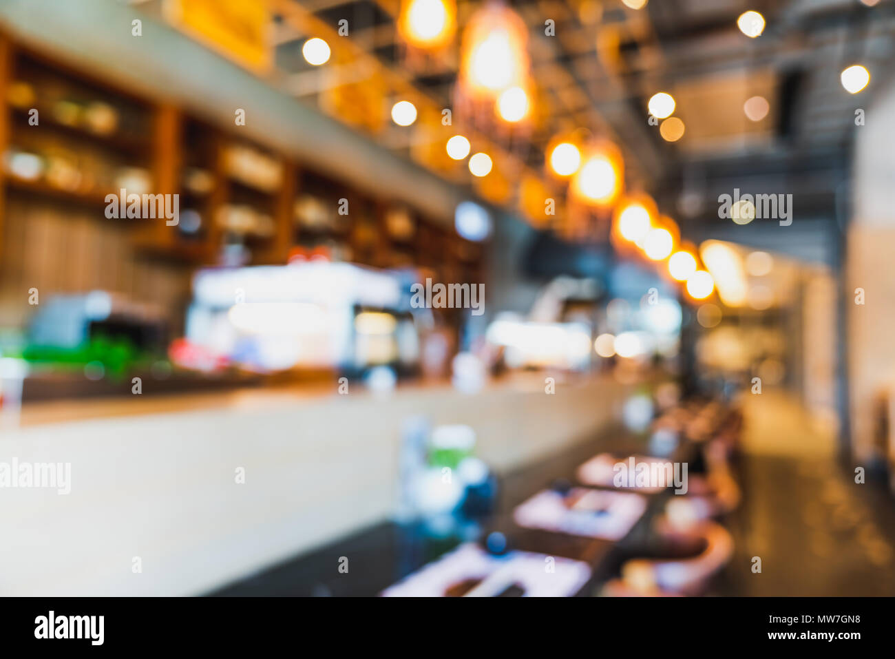 Blurred, defocused background of modern Japanese restaurant's empty counter bar with bokeh lights. Food and drink industry, coffee shop or cafe Stock Photo