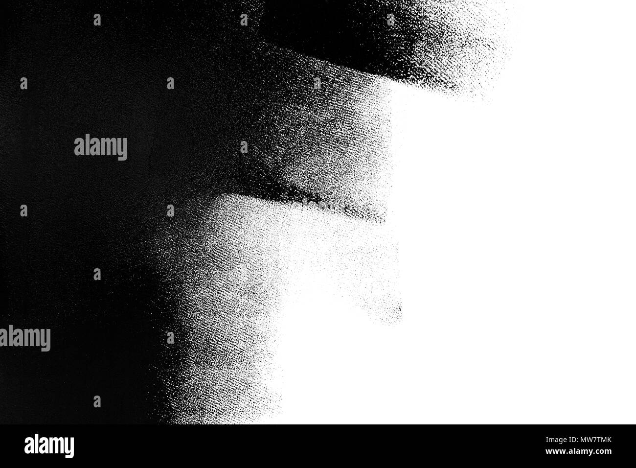 White wall partially painted in black with a paint roller Stock Photo