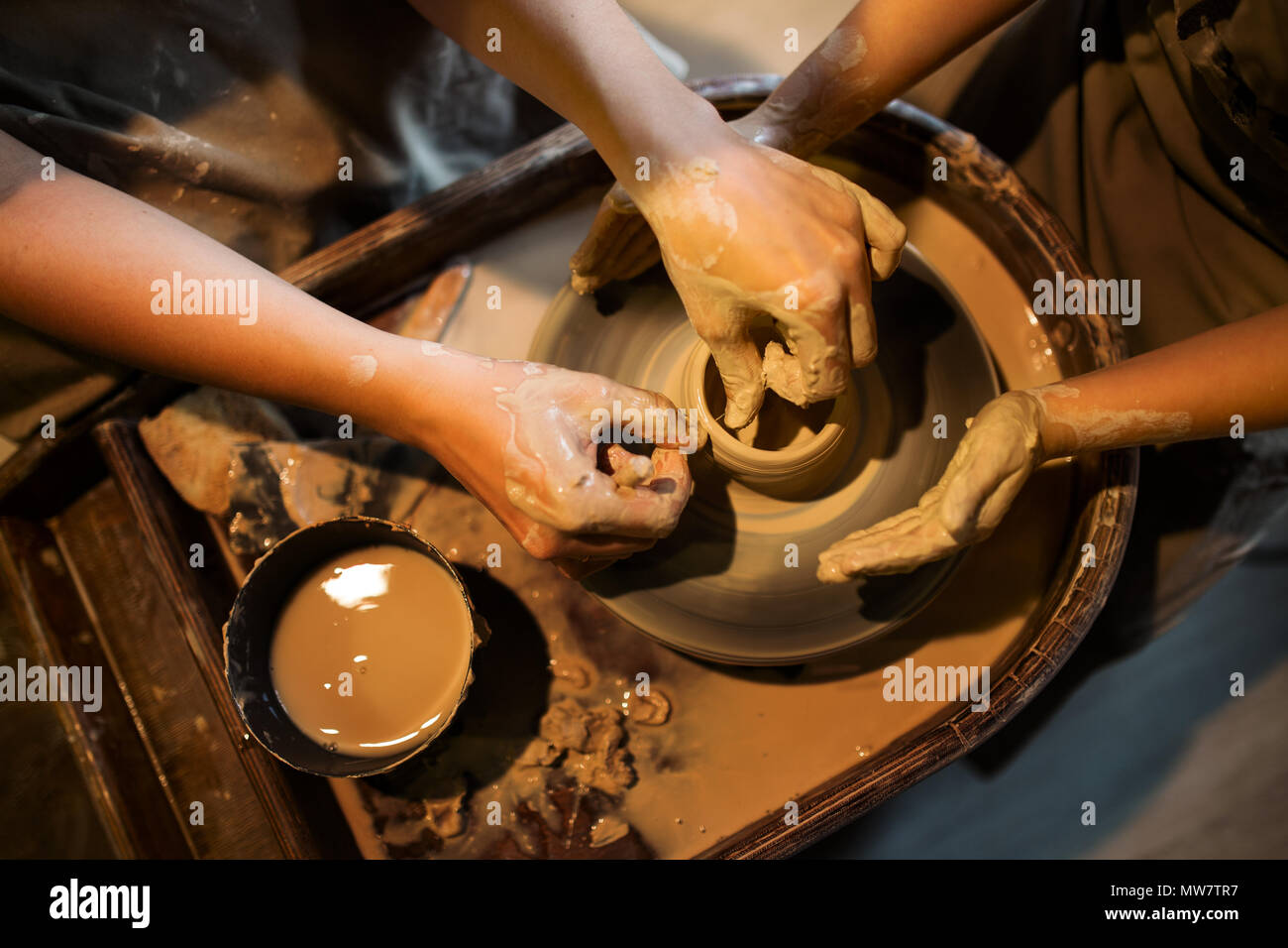 Master potter teaches the child to work on the Potter's wheel. Close up shot Stock Photo