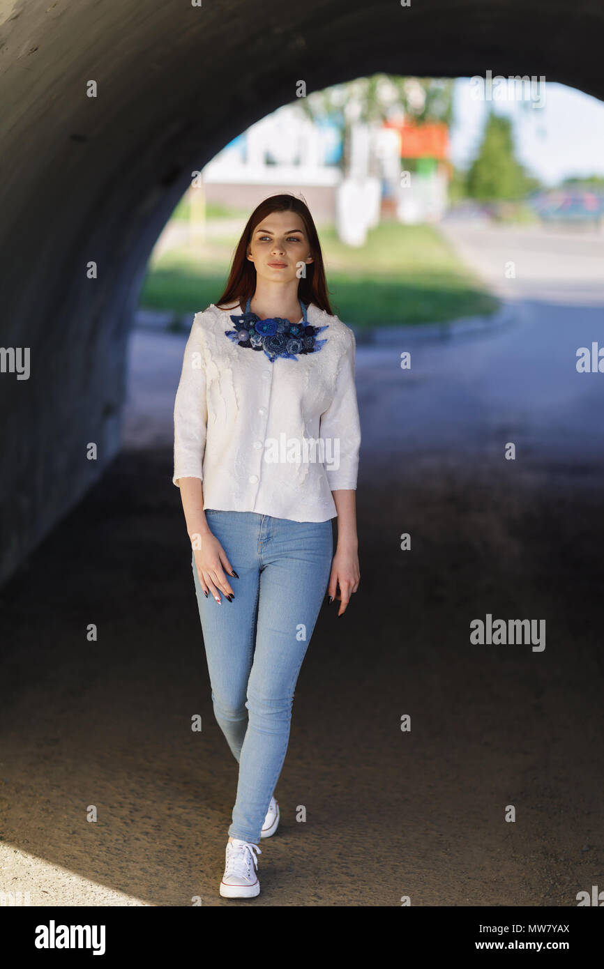 Modern street clothes made by own hands - Stylish beautiful girl defiles in a white jacket Stock Photo