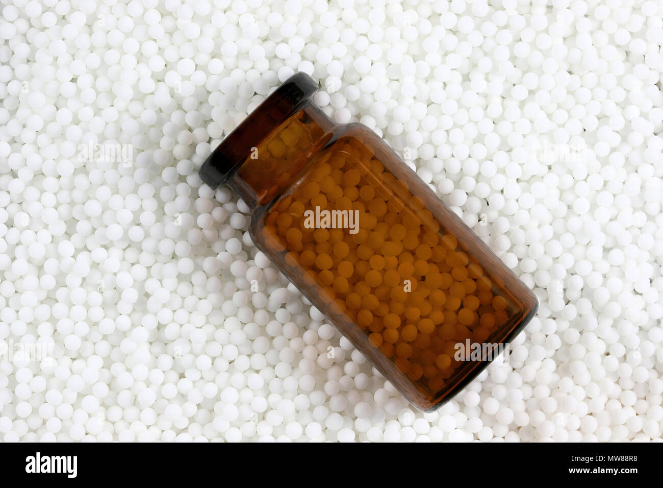brown bottle within homeopathic pills Stock Photo