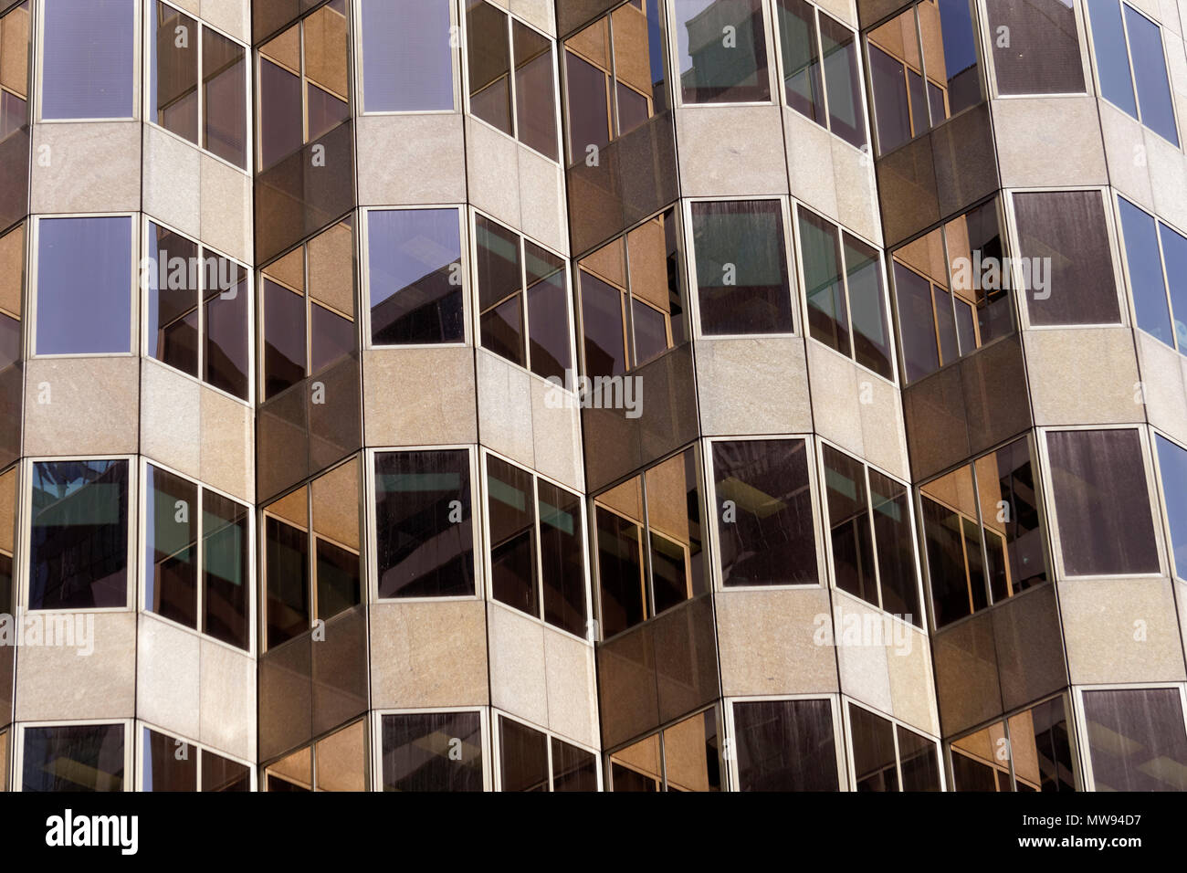 Rectangular windows of a high rise office building forming a repetitive pattern Stock Photo