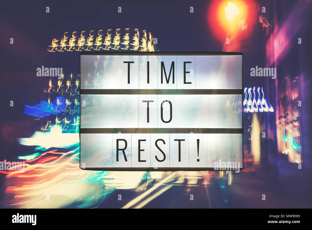 Time to Rest text in light box, motion blurred city lights in background, color toned picture. Stock Photo