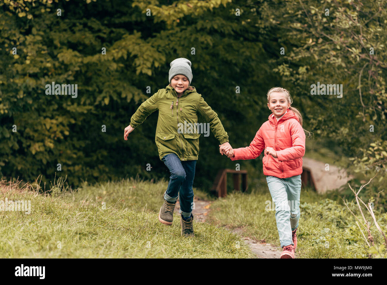adorable little kids holding hands and running in autumn park Stock ...