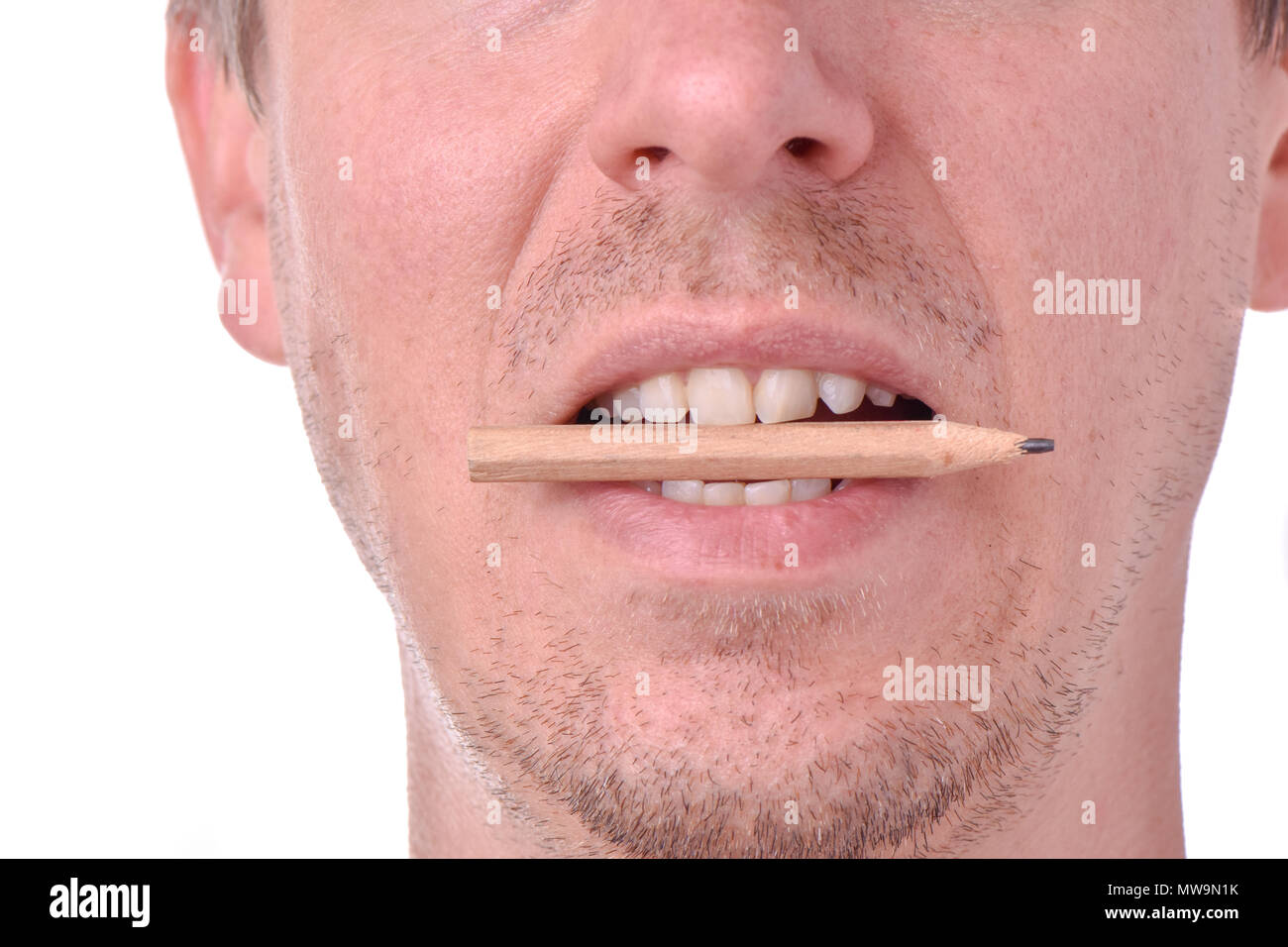 Close-up of man bitting pencil Stock Photo