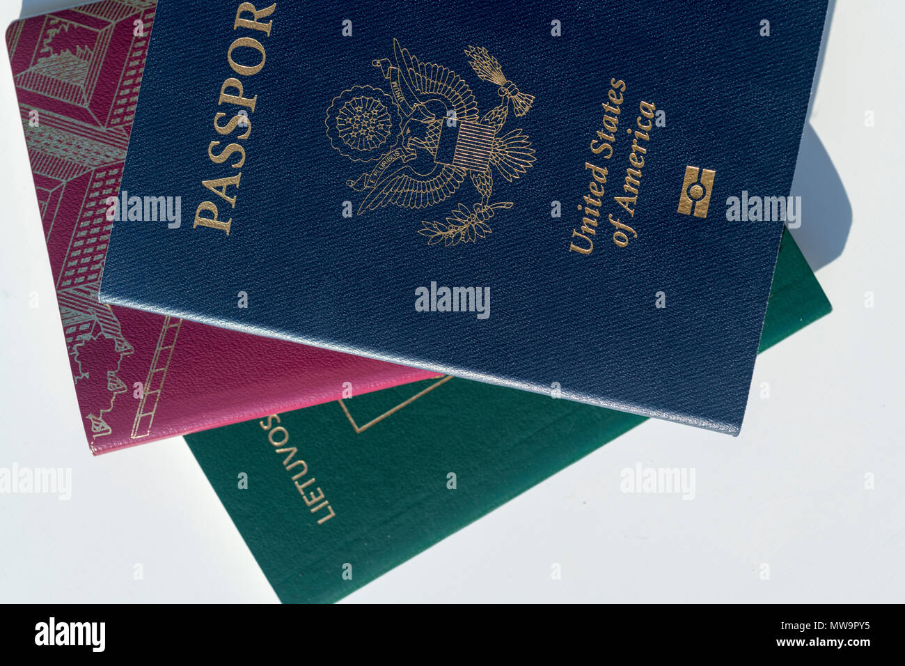 Dark blue US Passport Alongside EU Style Red and Green Passports Stock