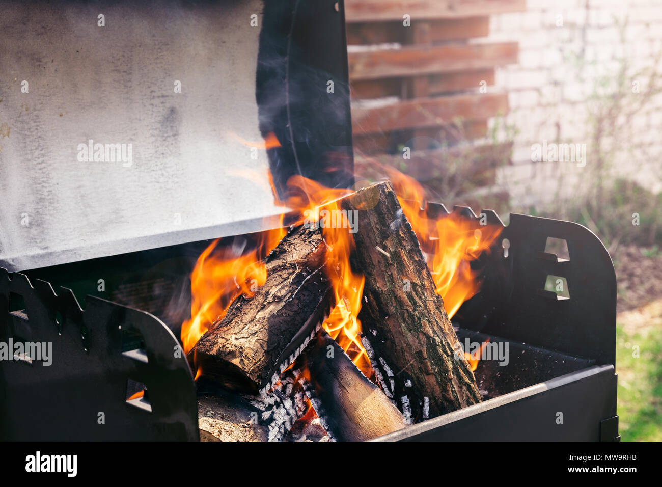 Fire over wooden logs in outdoors bbq Stock Photo