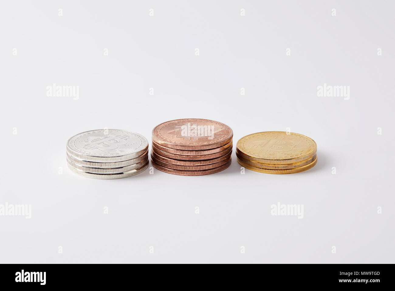stacks of golden, silver and bronze bitcoins on white Stock Photo - Alamy
