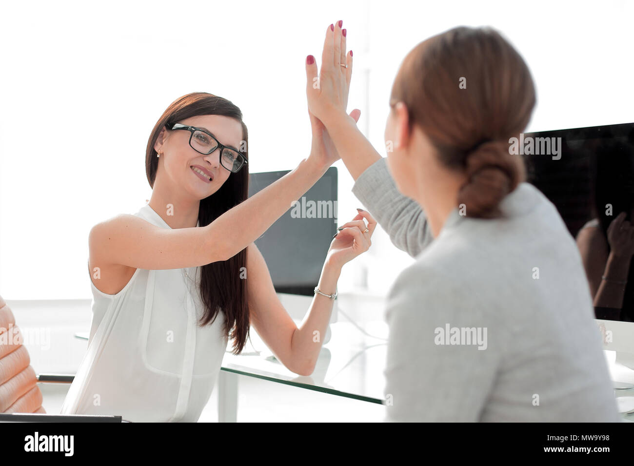 two employees giving each other a high five Stock Photo - Alamy