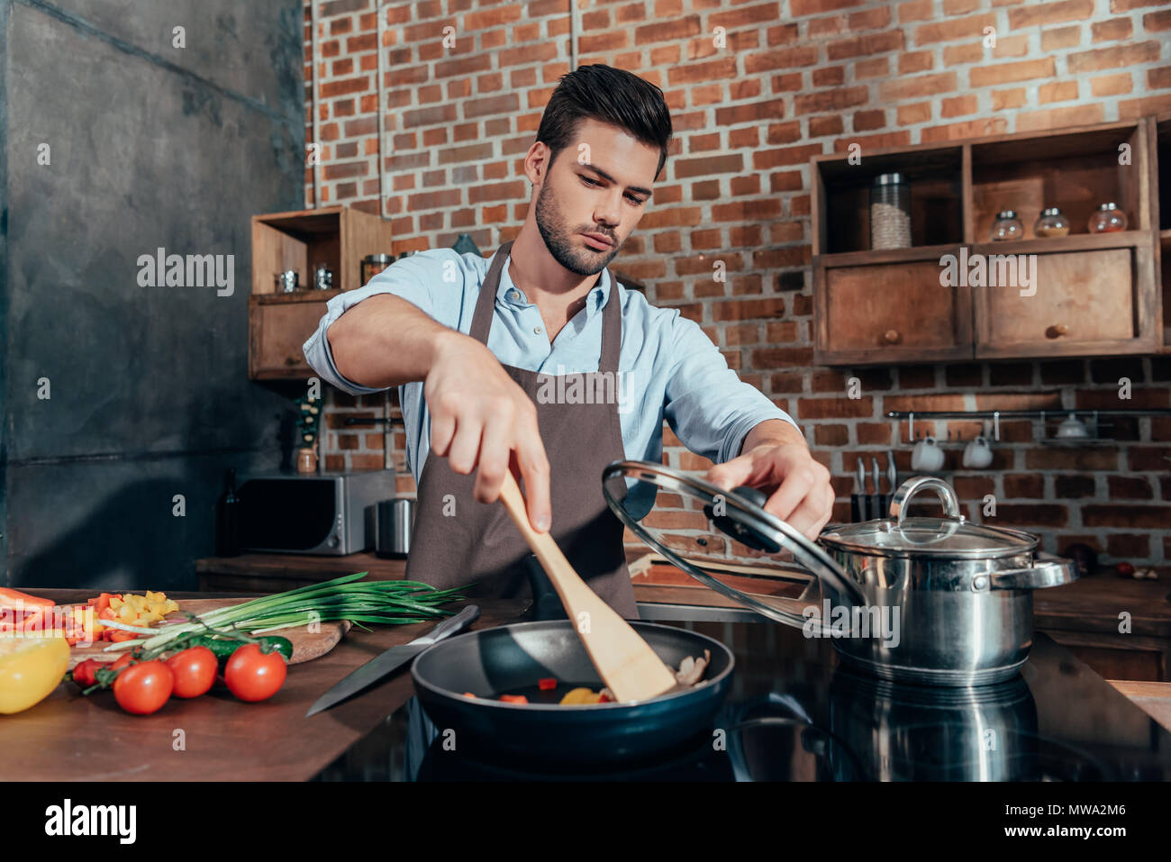 pensive handsome man with apron cooking Stock Photo - Alamy
