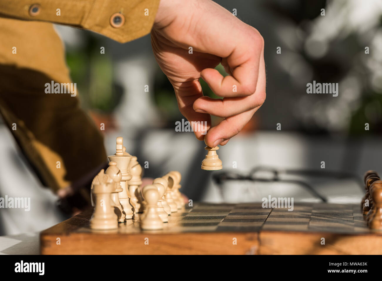 cropped shot of man making move while playing chess Stock Photo - Alamy