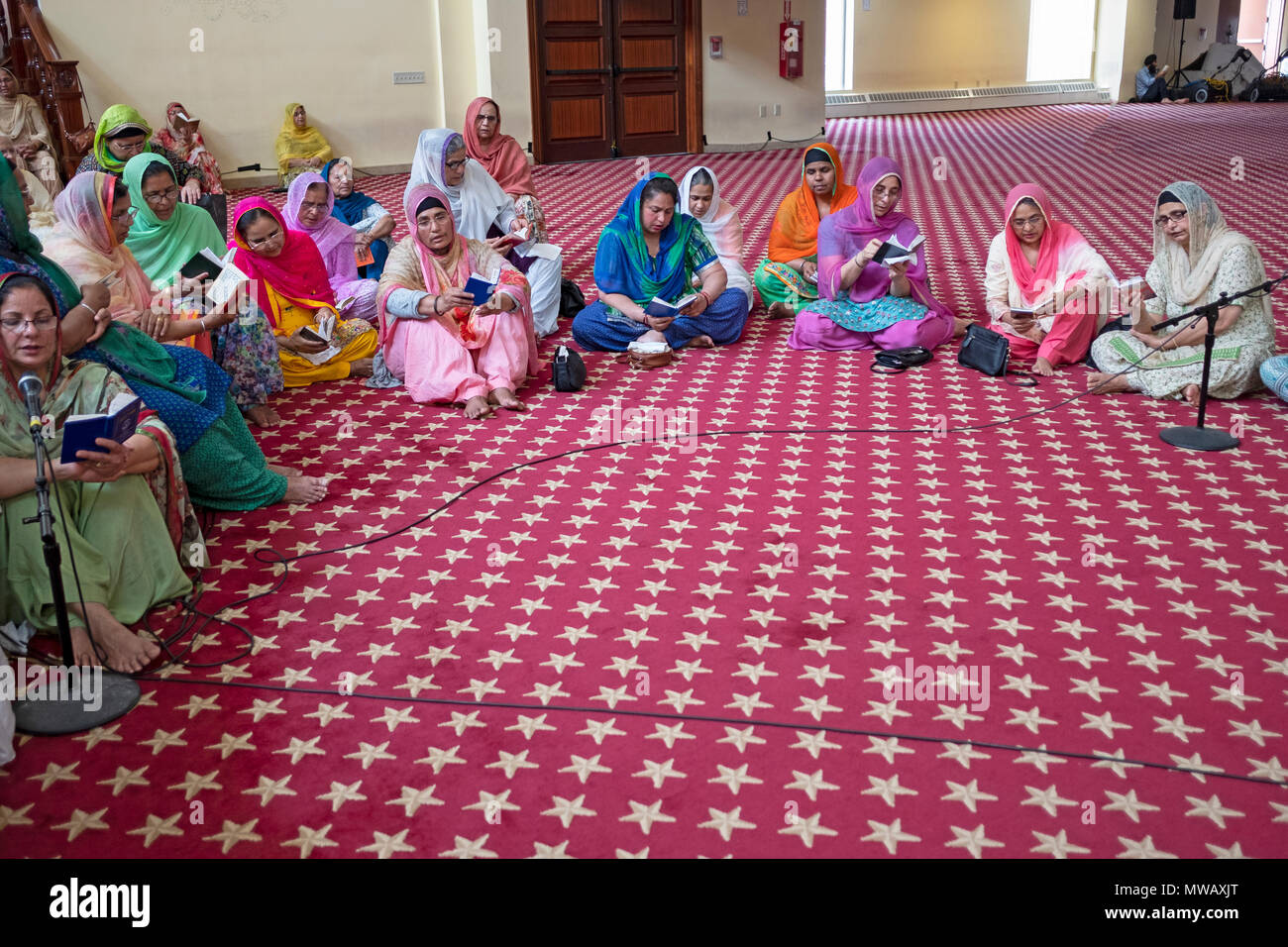 A group of Sikh women praying in anticipation of the festival of Martyrdom of Guru Arjan at the Gurdwara Sikh Cultural Society. Richmond Hill, Queens. Stock Photo