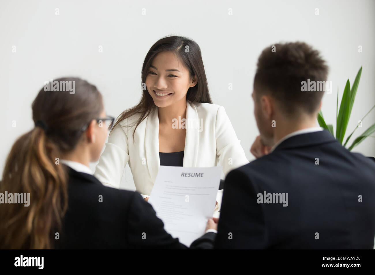 Confident beautiful millennial asian applicant smiling at job in Stock Photo