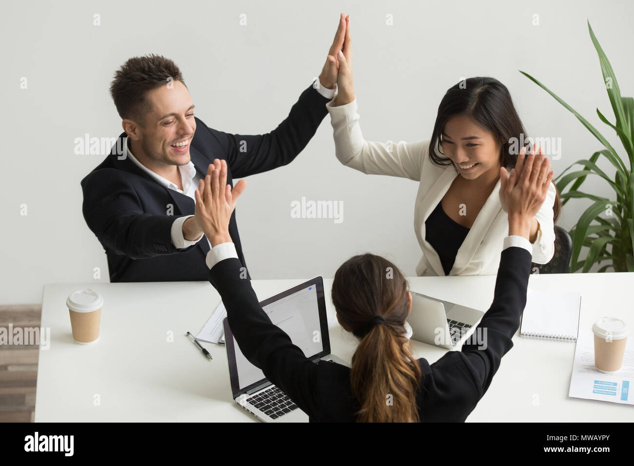 Excited multiracial team holding hands giving high five celebrat Stock ...